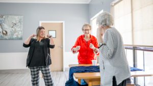 A nurse and two women residents at Chambers Health and Rehab laugh and smile while spending time together